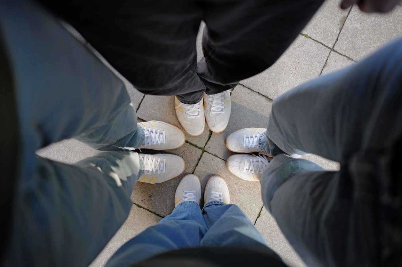 Vier Paar gleiche Sneaker im Kreis: das Still-Alive-Team
